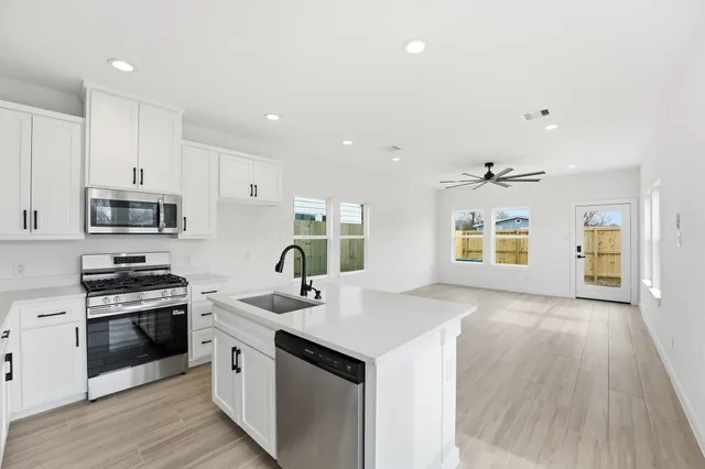 a kitchen with stainless steel appliances a sink stove and cabinets