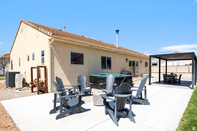 7776 Wagon Road East St. George, UT 84770 - Photo 51 of 76 Back of property with a patio area, outdoor dining space, stucco siding, a hot tub, and a gazebo