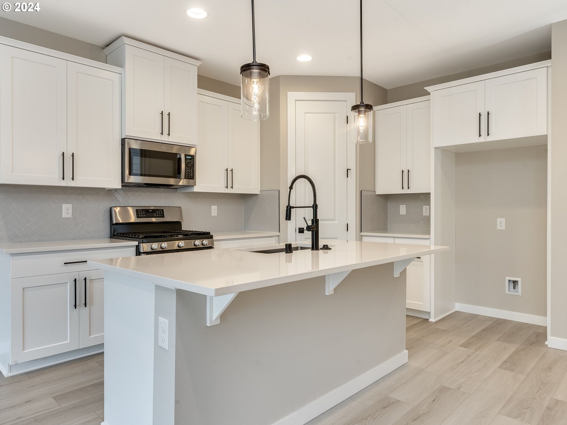 834 Northwest 178th Street Ridgefield, WA 98642 - Photo 7 of 36 a kitchen with stainless steel appliances a sink a stove a refrigerator white cabinets and wooden floor