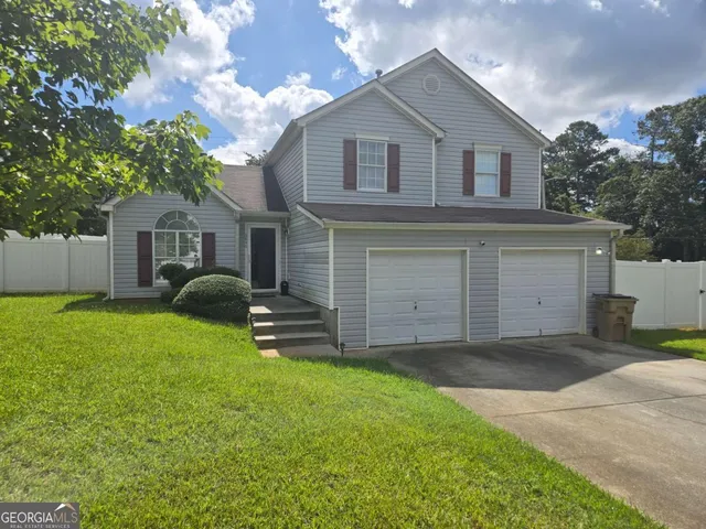 a front view of a house with a garden and yard