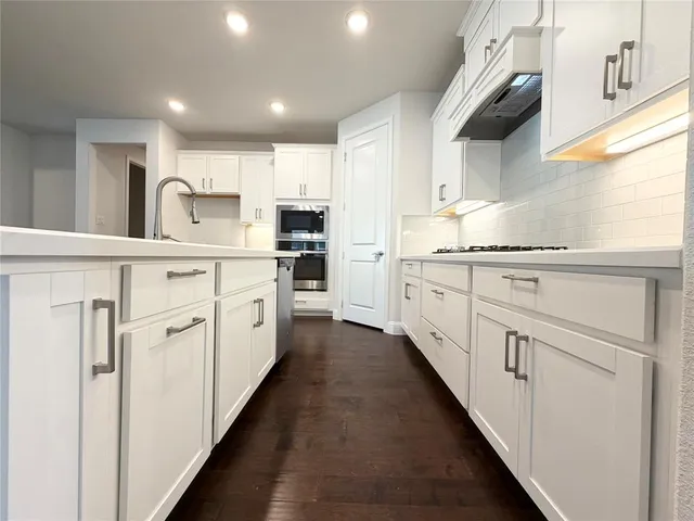 a kitchen with white cabinets and white appliances