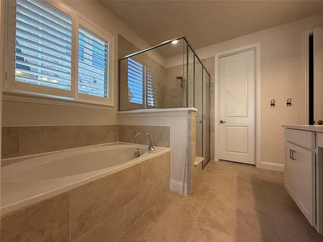 a spacious bathroom with a bathtub and a shower
