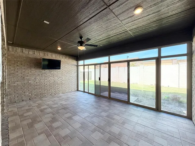 a view of an empty room with wooden floor and a balcony