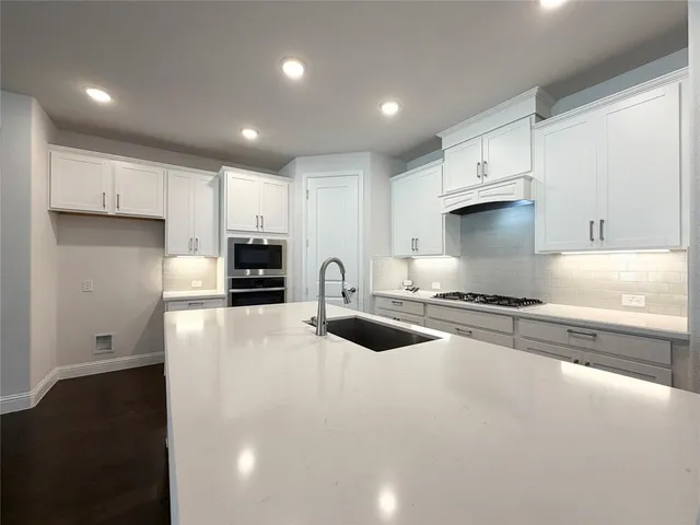 a kitchen with stainless steel appliances granite countertop a stove a sink and a refrigerator