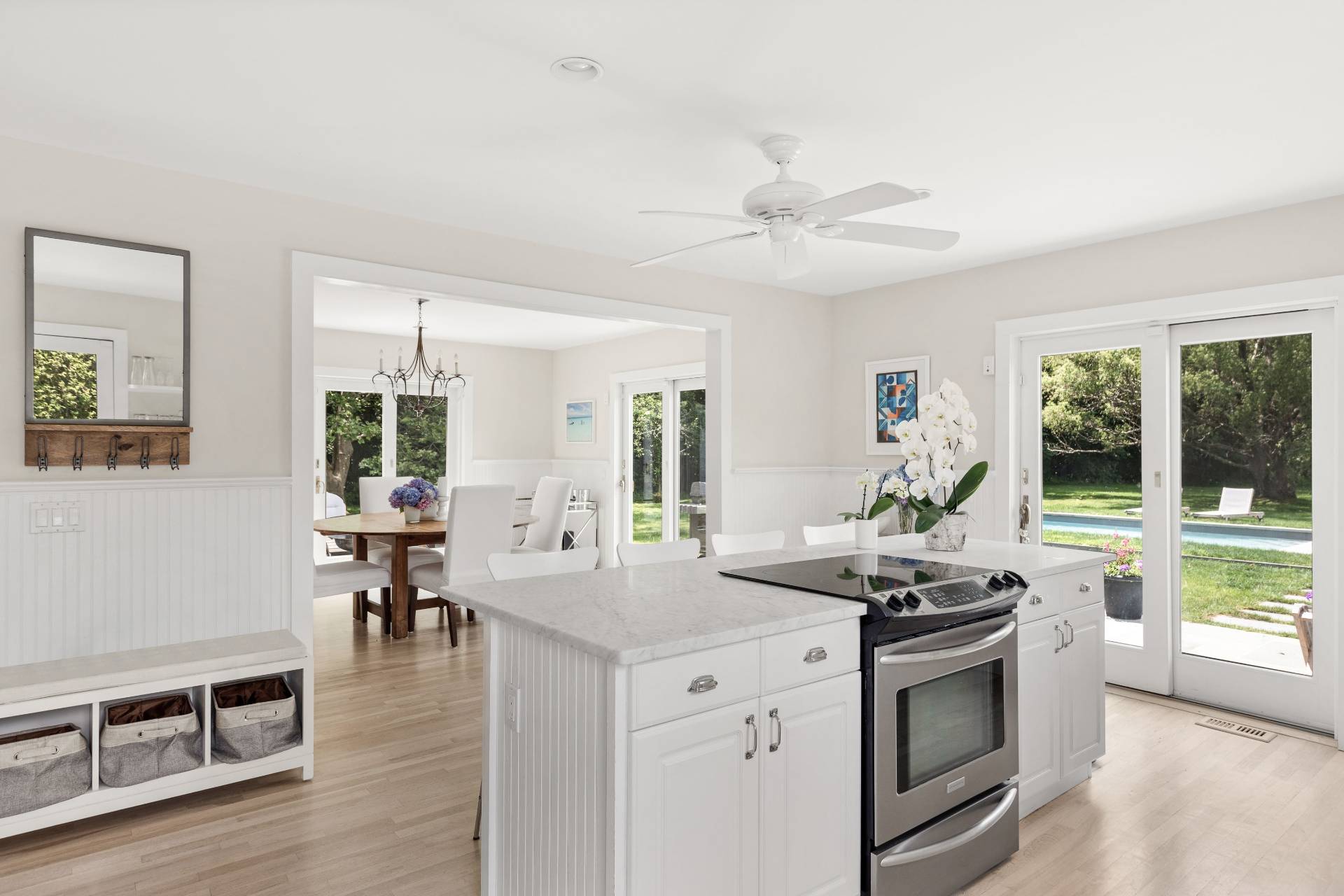 124 Ocean Road Bridgehampton, NY 11932 - Photo 12 of 27 a kitchen with stainless steel appliances a stove a sink a dining table and chairs with wooden floor