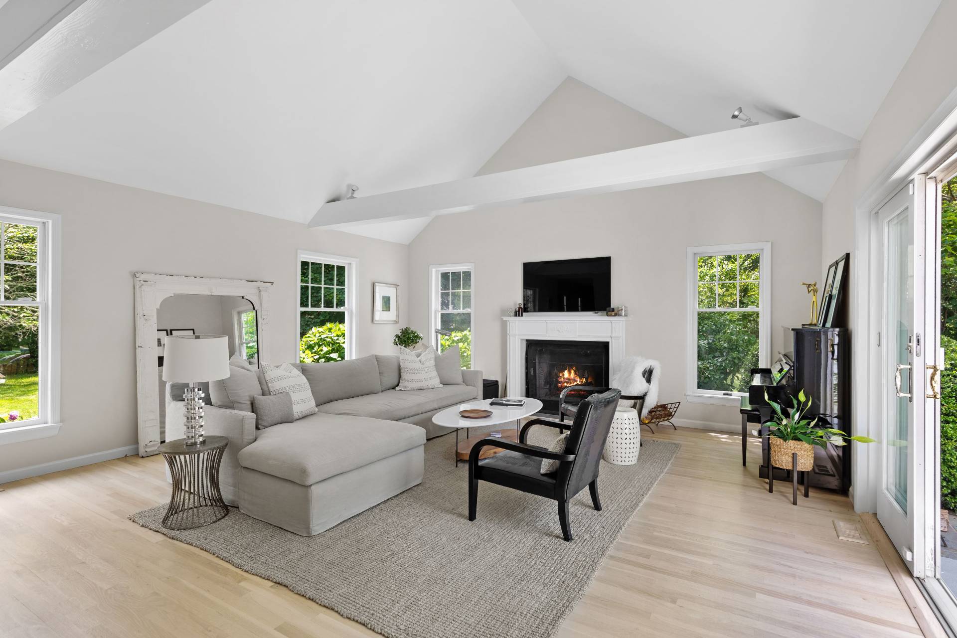 124 Ocean Road Bridgehampton, NY 11932 - Photo 8 of 27 a living room with furniture a fireplace a flat screen tv and a large window