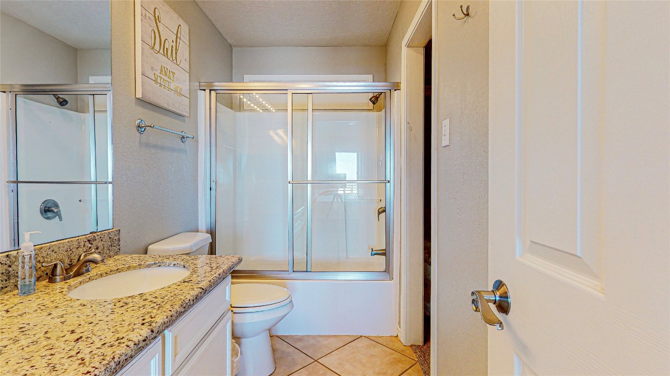 3433 Sand Castle Lane Crystal Beach, TX 77650 - Photo 19 of 30 a bathroom with a granite countertop sink toilet and shower