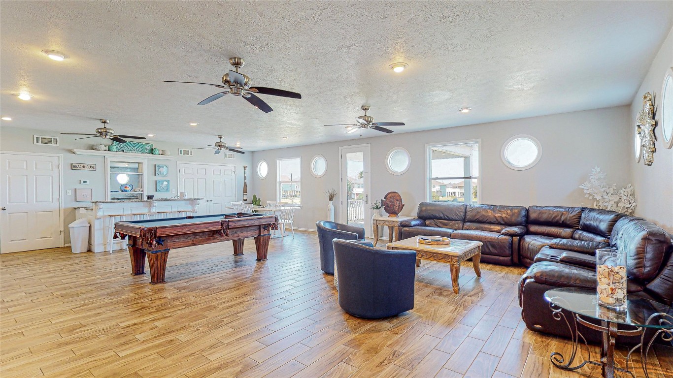 3433 Sand Castle Lane Crystal Beach, TX 77650 - Photo 5 of 30 a living room with furniture a table and wooden floor