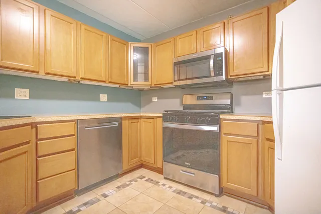 a kitchen with stainless steel appliances granite countertop a sink a stove and a refrigerator