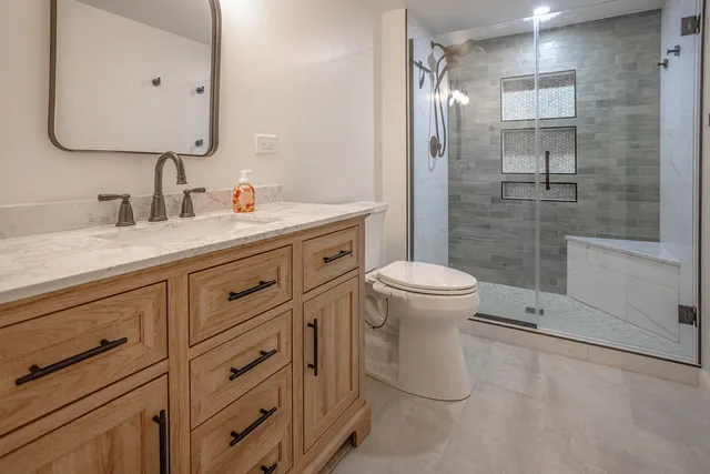 a bathroom with a granite countertop sink toilet and shower