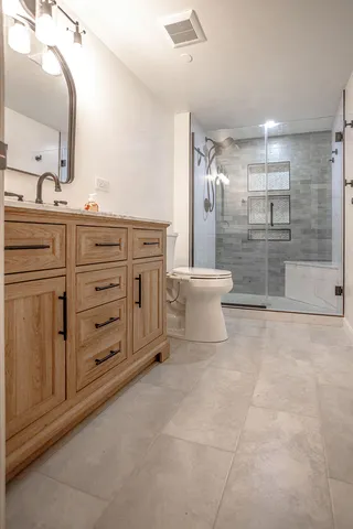 a bathroom with a sink a toilet and shower