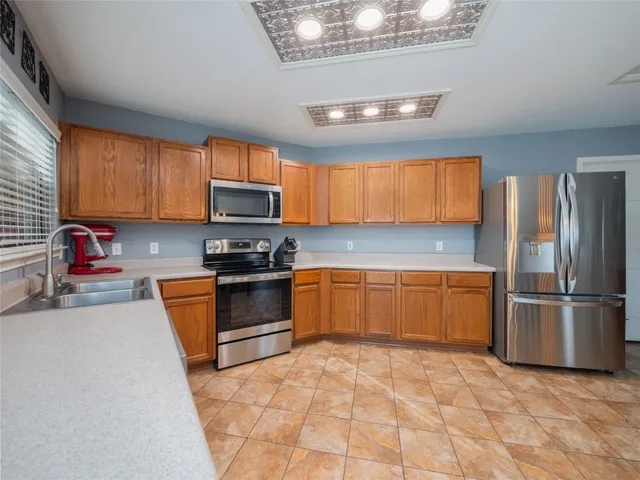 a kitchen with granite countertop a refrigerator and a stove top oven