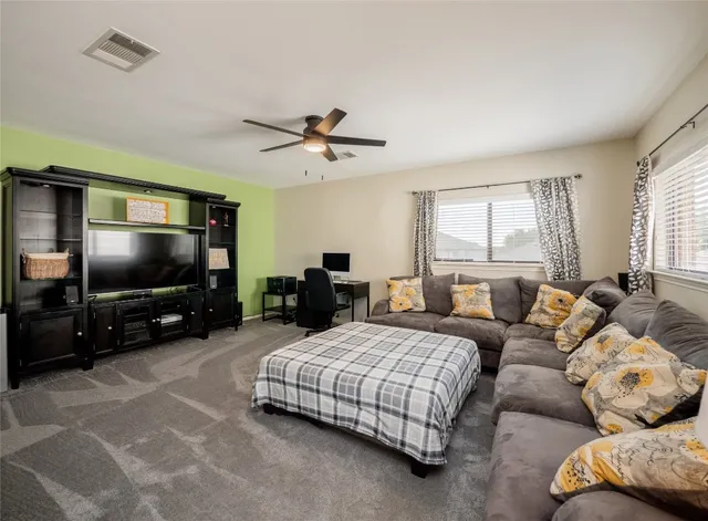 a living room with furniture flat screen tv and windows