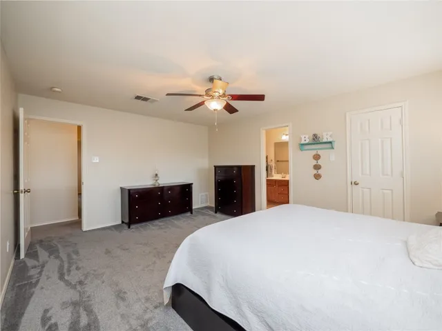 a bed room with a bed and a ceiling fan