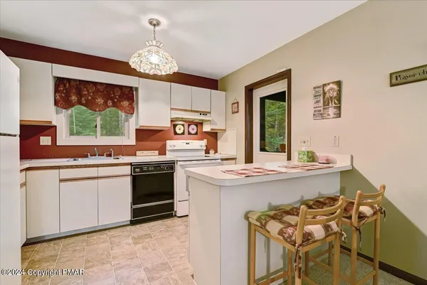 a kitchen with a stove a sink a dining table and chairs