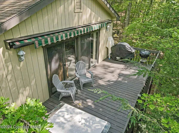 a view of a chair and tables in the patio along the house