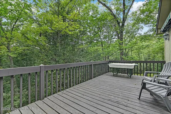 a view of a deck with chairs a barbeque with wooden floor and fence