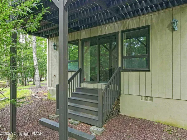 a view of a house with a floor to ceiling window and wooden fence