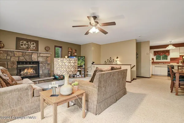 a living room with furniture a fireplace and kitchen view