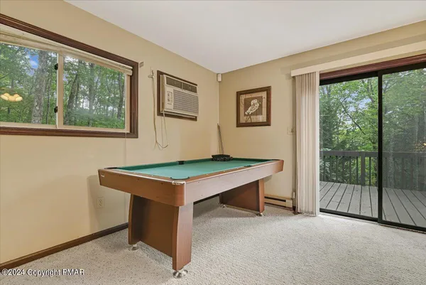 a room with pool table and windows