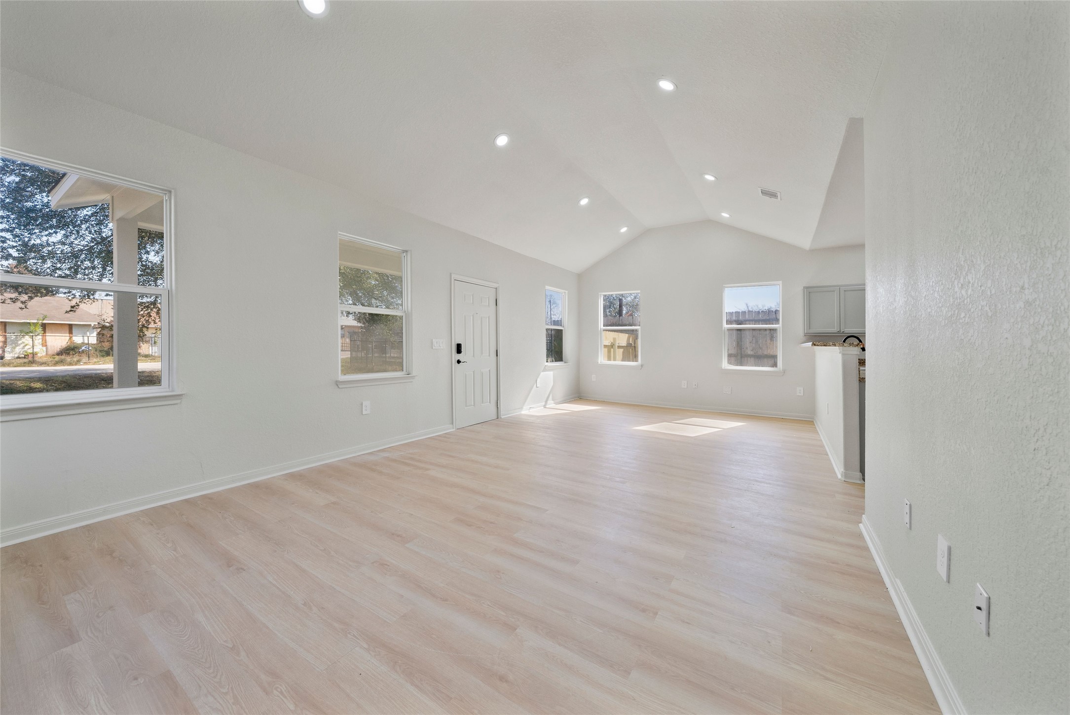 a view of empty room with wooden floor and windows