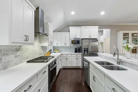 a kitchen with a sink stove top oven and cabinets