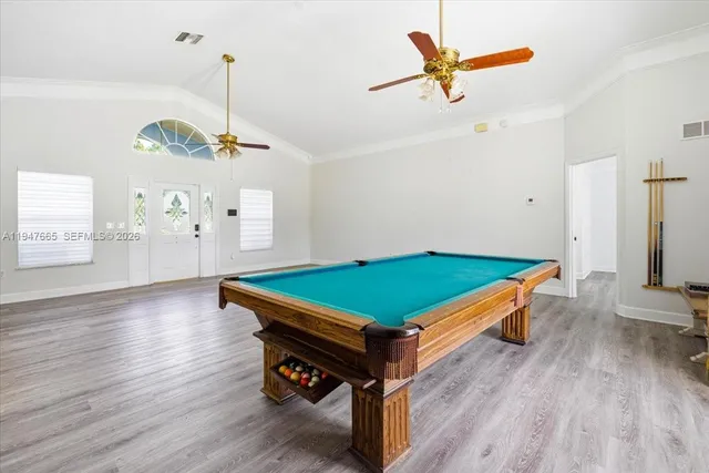 a room with pool table and windows