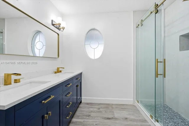 a bathroom with a double vanity sink mirror and shower