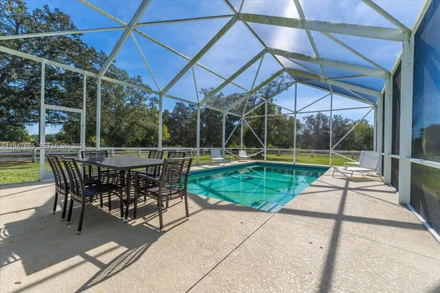 a view of a swimming pool with a patio and a yard