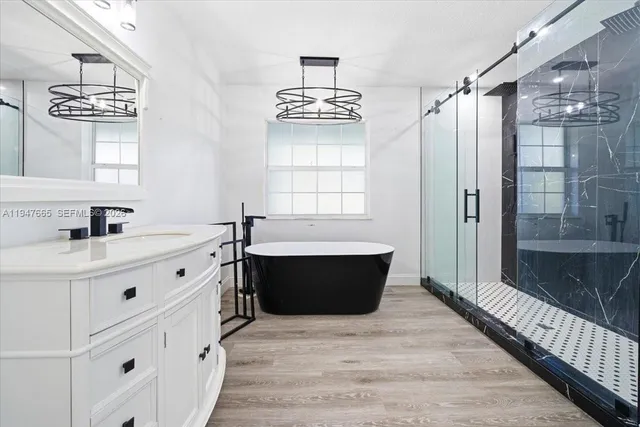 a bathroom with a double vanity sink mirror and bathtub