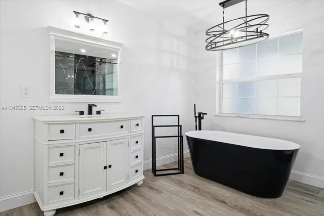 a bathroom with a double vanity sink a mirror and bathtub