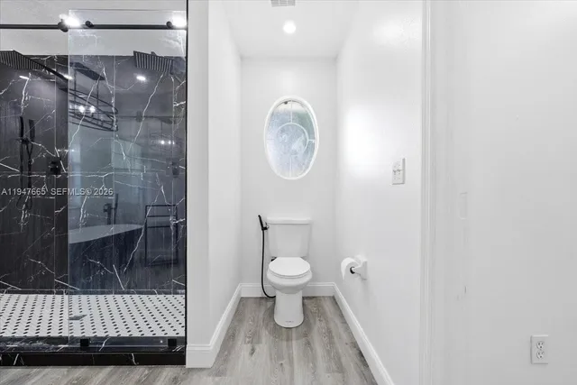 a bathroom with a toilet and a shower