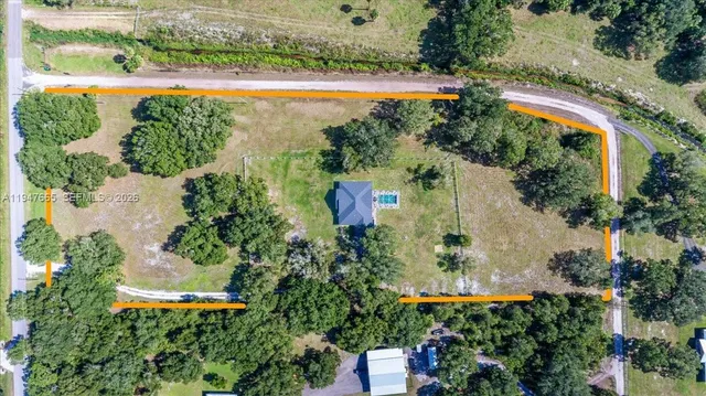 an aerial view of a house with a garden and lake view