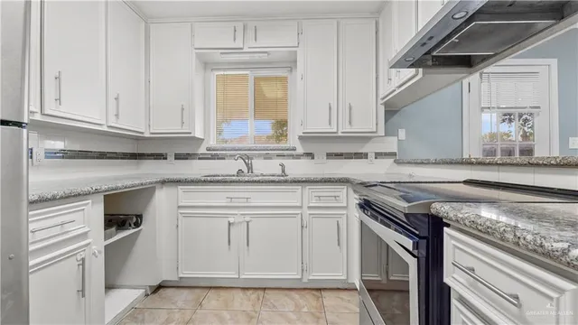 a kitchen with granite countertop cabinets stainless steel appliances and a sink