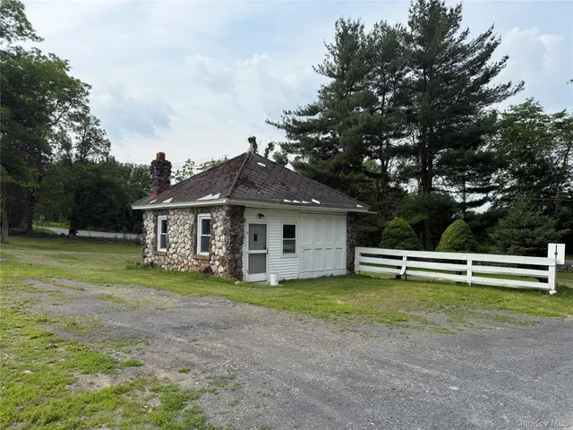 a view of a house with a yard and sitting area