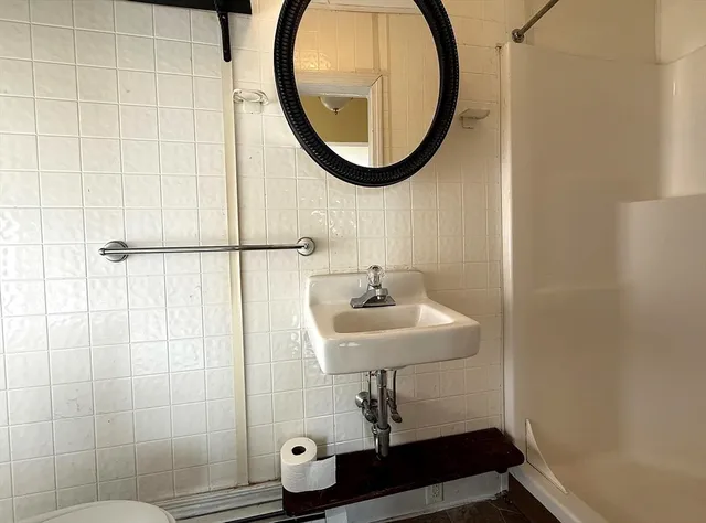 a bathroom with a sink toilet and a mirror