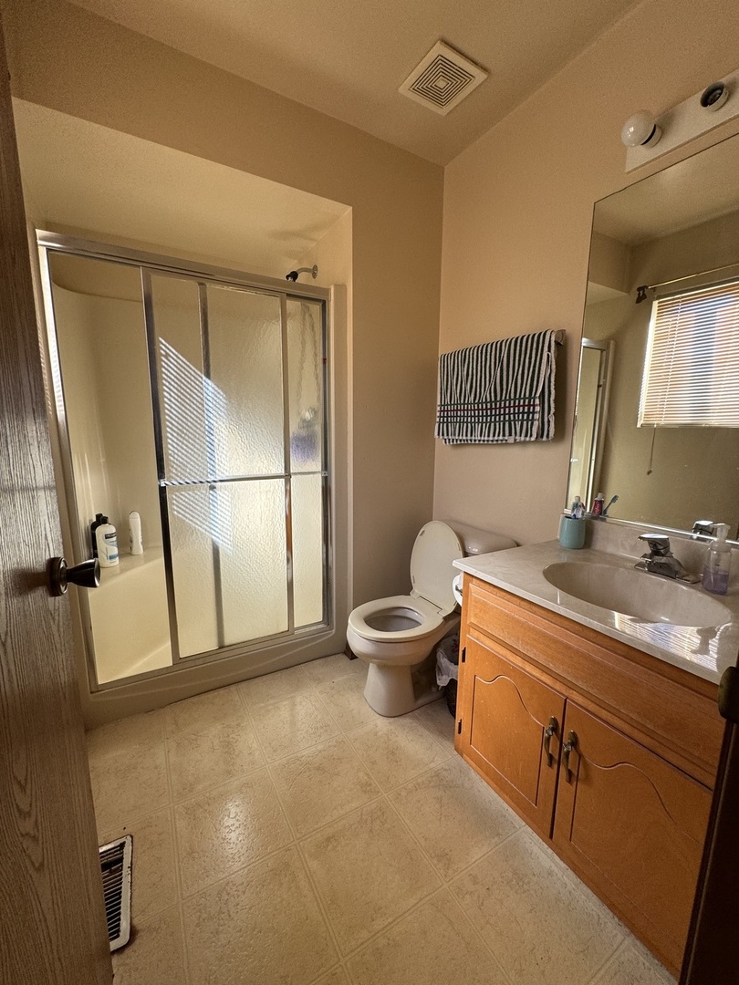 209 Churn Road Matteson, IL 60443 - Photo 25 of 26 a spacious bathroom with a double vanity sink a mirror and a toilet