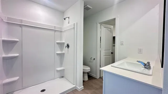 a bathroom with a granite countertop sink toilet and shower