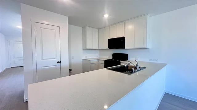 a kitchen with a sink stove and microwave