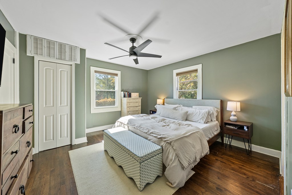 7047 Mellwood Road Columbus, GA 31904 - Photo 17 of 34 a bedroom with a large bed a chandelier and windows