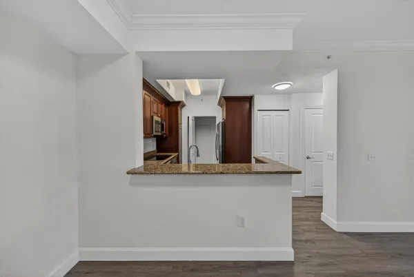a view of a kitchen with kitchen island a sink and wooden floor