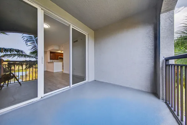 a view of a hallway with wooden floor and a glass door