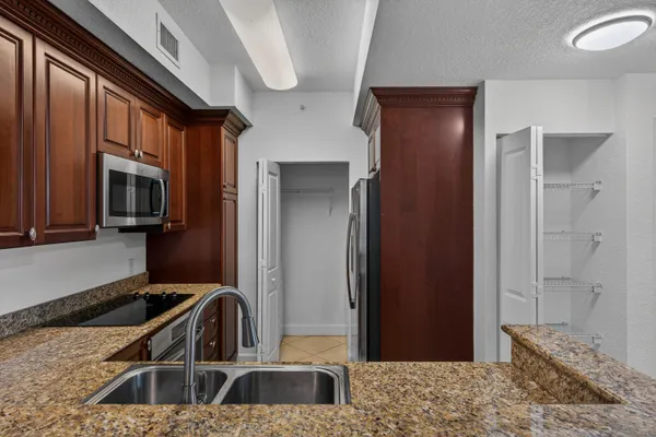 a kitchen with stainless steel appliances granite countertop a sink stove and refrigerator