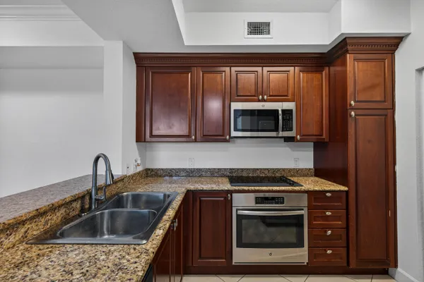 a kitchen with granite countertop a stove and a sink