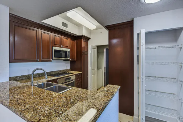 a kitchen with granite countertop wooden cabinets and stainless steel appliances