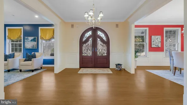 a kitchen with stainless steel appliances kitchen island granite countertop a refrigerator a stove top oven a sink dishwasher and white cabinets with wooden floor