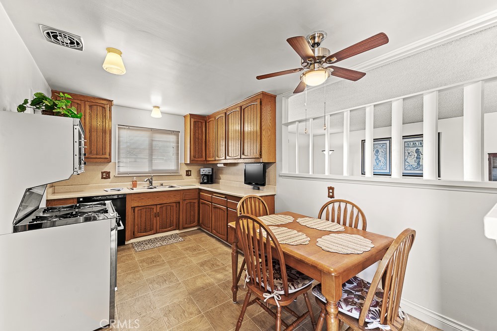 10282 Longden Street Cypress, CA 90630 - Photo 19 of 43 a kitchen with a dining table chairs stainless steel appliances and cabinets