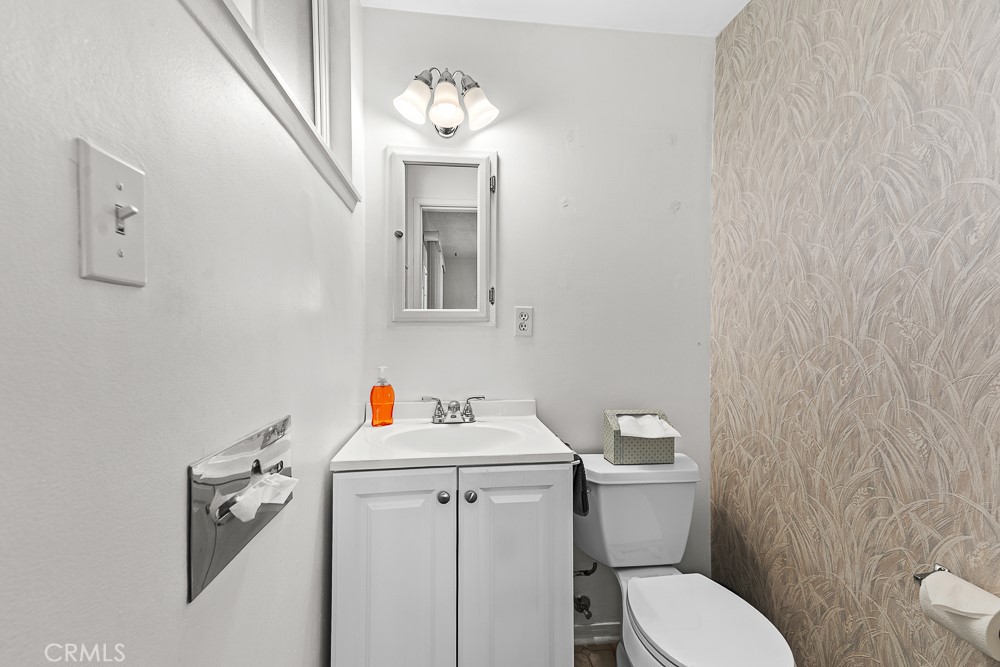 10282 Longden Street Cypress, CA 90630 - Photo 23 of 43 a bathroom with a toilet sink and mirror