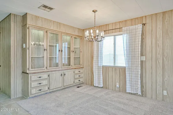a spacious bathroom with windows and chandelier