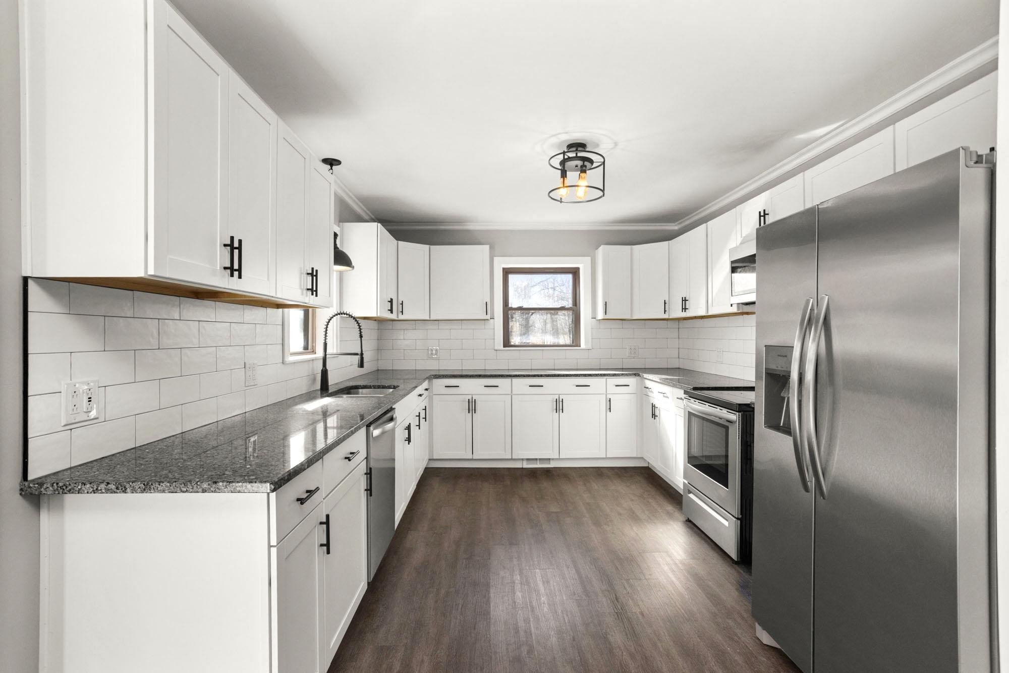 1300 Ridge Road Dickson, TN 37055 - Photo 23 of 60 a kitchen with granite countertop a refrigerator a sink dishwasher a stove and white cabinets with wooden floor